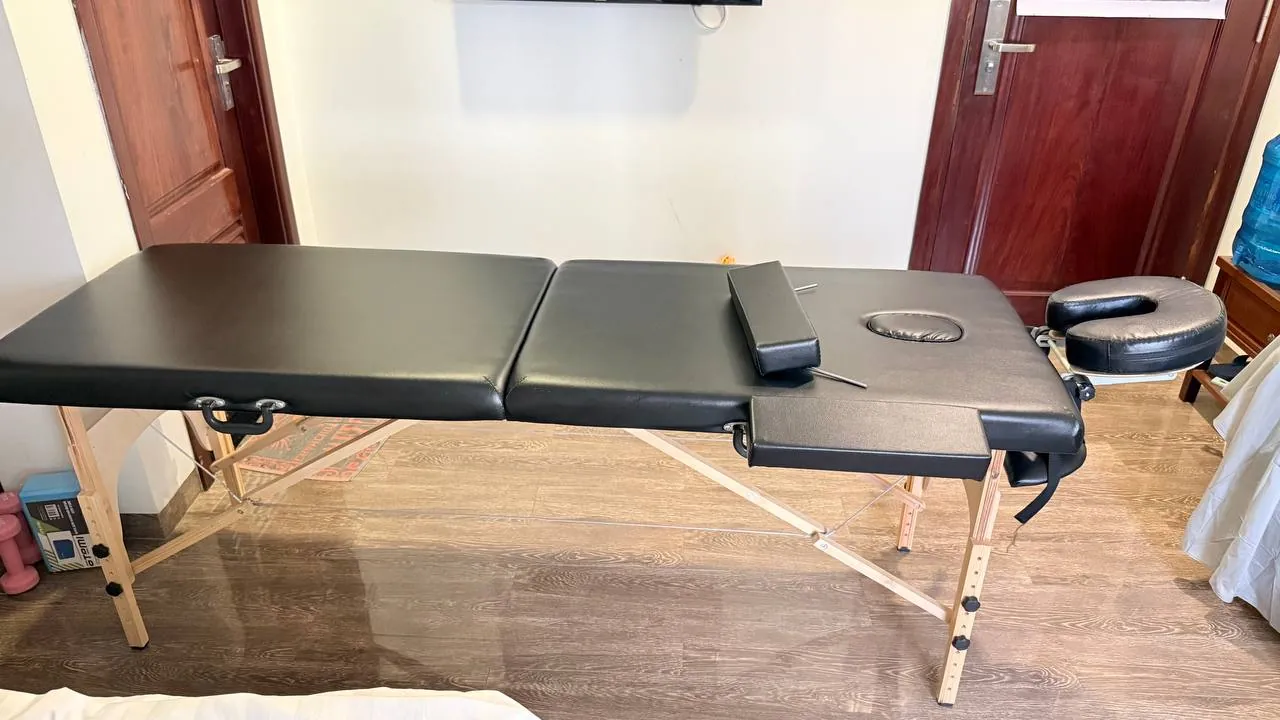 Massage table with a roll of disposable sheets